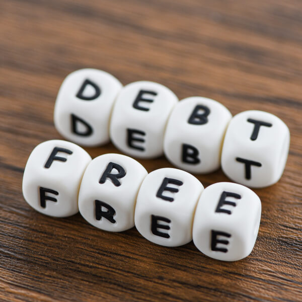 Dés désignant "débarrassé des dettes" et "libre", symbolisant la liberté financière.