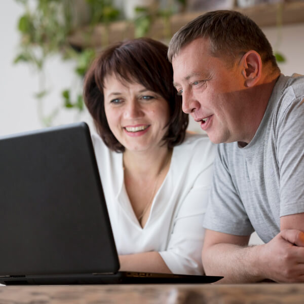 Un homme et une femme regardent un ordinateur portable, discutant d'un prêt rapide en ligne.