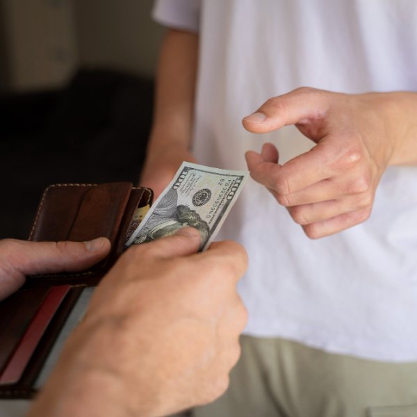 Remise d’argent en espèces illustrant une option traditionnelle d’aide financière